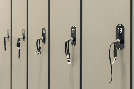Grey Cabinets with Numbered Locks and Keys in School, Gym or Locker Room