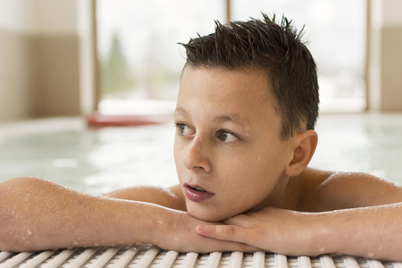 Portrait of Smiling Teen Boy in a Swimming Pool With Copy Spaceの写真素材