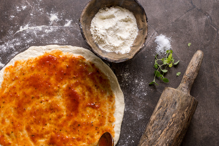 Raw Pizza Dough and Rolling Pin with Ingredients. Italian Pizza Making Concept.の写真素材