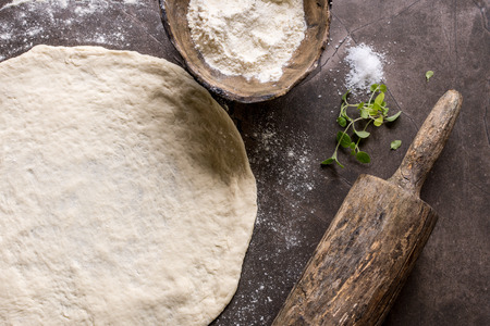 Raw Pizza Dough and Rolling Pin with Ingredients. Italian Pizza Making Concept.の写真素材