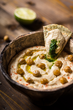 Homemade Chickpea Hummus in Rustic Bowl with Olive Oil and Fresh Pita Breadの写真素材