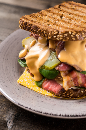 Big Homemade Sandwich with Roast Beef, Bacon, Pickles, Baby Spinach and Coleslaw Dressing in Toasted Breadの写真素材