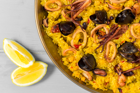 Seafood Paella in Traditional Pan on Rustic Wooden Tableの写真素材