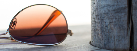 Brown Mirrored Sunglasses Detail on the Wooden Background Close Up and Selective Focus. Fashion Concept.の写真素材