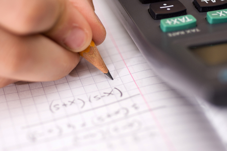 Child Holds the Pencil in his Hand and Solves Mathematical Problems. School, Education and Learning...