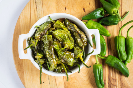 Fried Green Padron Peppers in White Bowl. Pimientos de Padron.の写真素材