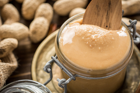 Homemade Peanut Butter in Glass Jar. Healthy Breakfast.