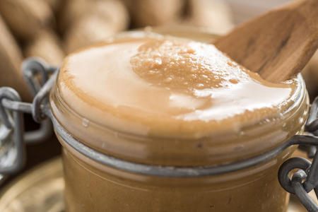 Homemade Peanut Butter in Glass Jar. Healthy Breakfast.