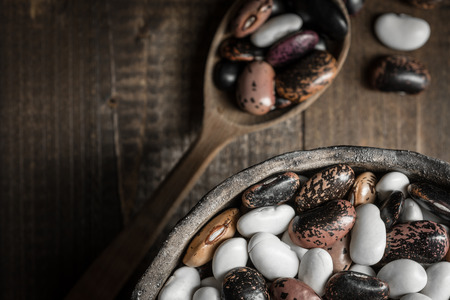 Raw Colorful Beans on Dark Wooden Backgroundの写真素材
