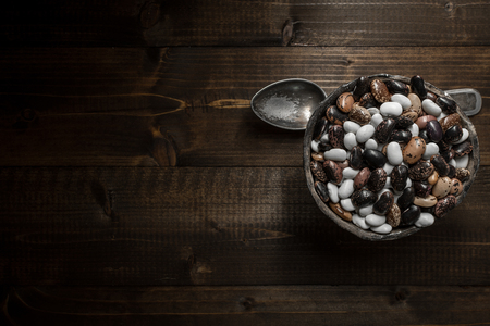 Raw Colorful Beans on Dark Wooden Backgroundの写真素材