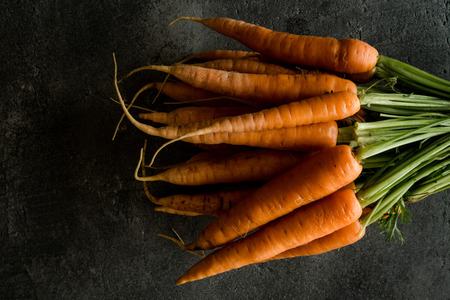 Organic Nantes Carrots on Rustic Dark Background.の写真素材
