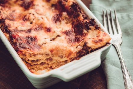 Italian Lasagna Bolognese and Mozzarella Cheese on Dark Wooden Backgroundの写真素材