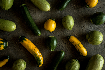 Yellow and Green Round Zucchini on Rustic Dark Backgroundの写真素材