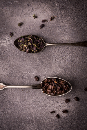 Tea and Coffee Beans in Rustic Spoons over Dark Stone Backgroundの写真素材