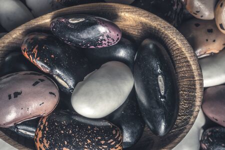 Organic Colorful Beans and Rustic Wooden Spoon on Dark Backgroundの写真素材