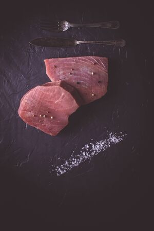Fresh Steak of Raw Tuna on Dark Stone Background
