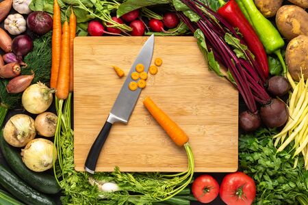 Chef Knife on Wooden Cutting Board with Fresh Vegetables Background. Vegan Raw Food. Healthy Eating Concept.の写真素材