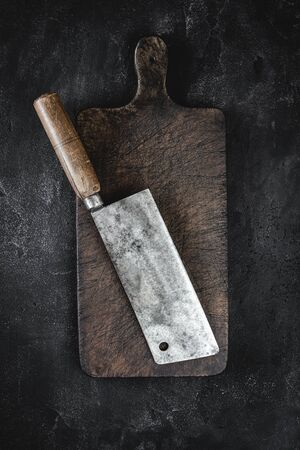 Rustic Cutting Board and Meat Cleaver on Dark Background. Butcher Shop Tool.の写真素材