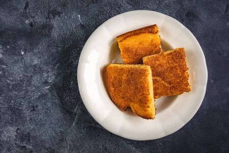 Corn Bread Squares Slices in White Plate on Dark Blue Rustic Backgroundの写真素材