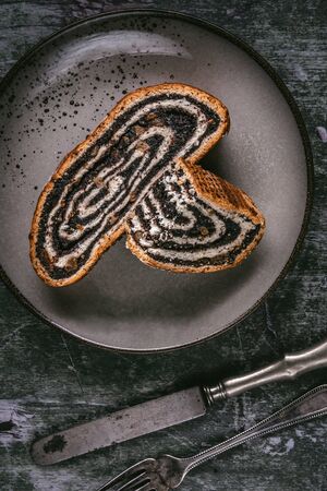 Poppy Seeds Strudel Roll Pie Slices on Rustic Plate and Green Backgroundの写真素材