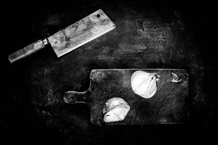 Rustic Meat Cleaver and Cutting Board on Dark Background in Black and White. Butcher Shop Tools Concept.の写真素材