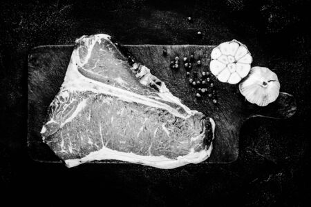 Dry Aged Premium Raw T-bone Steak on Rustic Kitchen Chopping Board. Black and White USDA Prime Beef.の写真素材