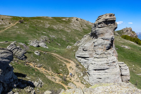 Ancient limestone high mountains of rounded shape in the air haze. The Valley of Ghosts. Demerji. Green trees and bushes in the foreground. May 2021. Crimea.の写真素材