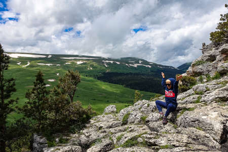 A little boy on the background of the alpine meadows of the Lago-Naki plateau in Adygea. Russia.の写真素材