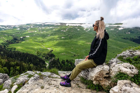 A girl on the background of alpine meadows of the Lago-Naki plateau in Adygea. Russia.の写真素材