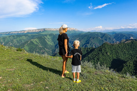 A girl with a child on the background of the Caucasus Mountains near the tract of Jila-Su. Russia.の写真素材