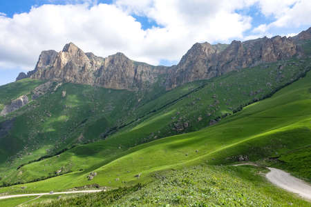 The landscape of the green Aktoprak pass in the Caucasus, the road and the mountains under gray...