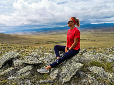 A girl on the background of a picturesque view of the Tazheran steppes. Irkutsk region, Russia....