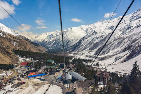Elbrus 2019. Cabs move up and down the cable car against the backdrop of mountain peaks and blue sky with cloudsの写真素材