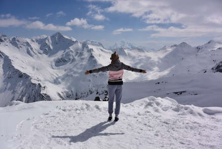 Girl on the background of snow-capped mountains. Caucasian mountains. Elbrus. Russia. April 25, 2019の写真素材