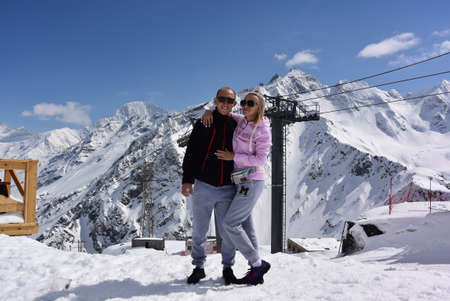 People on the background of the gondola cable car and the snow-capped mountains of Elbrus. April 2019. Elbrus. Russia.の写真素材