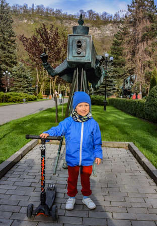 A boy in the park near the monument to the photographer in Borjomi, on a rainy day. Borjomi. Georgia 2019.の写真素材
