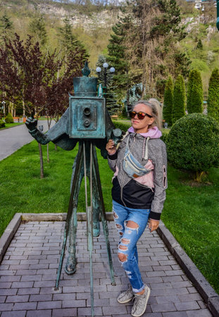 A girl in the park near the monument to the photographer in Borjomi, on a rainy day. Borjomi. Georgia 2019の写真素材