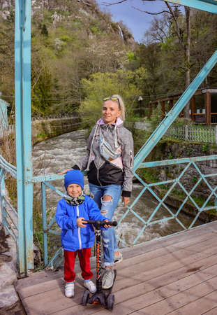 A girl with a child on a bridge on the main street of Borjomi in Georgia 2019.の写真素材