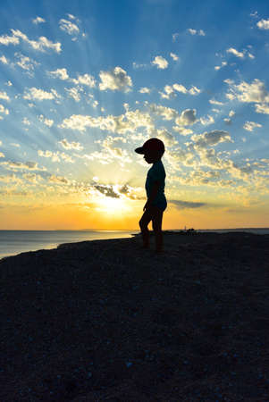 Happy child at sunset by the black sea.の写真素材