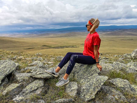 A girl on the background of a picturesque view of the Tazheran steppes. Irkutsk region, Russia. 2020.の写真素材