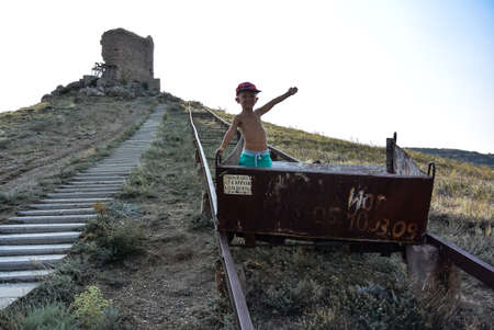 A boy in a cart near the fortress of Cembalo in Balaclava. Crimea 2019の写真素材