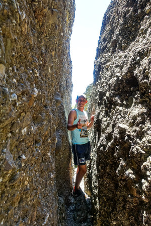 A man in a Broken heart stone, at the Demerdzhi tract. Crimea 2021.の写真素材