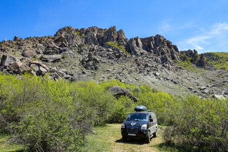 A car on the background of ancient limestone high mountains in an air haze. Demerji. Crimea. Russia 2021の写真素材