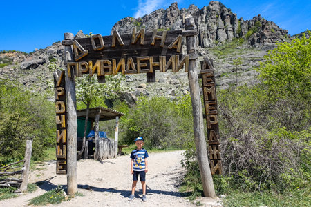 A little boy at the entrance to the Valley of Ghosts in the Demerdzhi tract. Crimea 2021.の写真素材