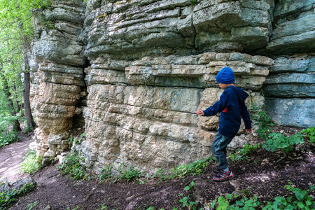 A little boy on the background of rocks in a picturesque forest on the way to the eagle shelf. Mezmai 2021の写真素材