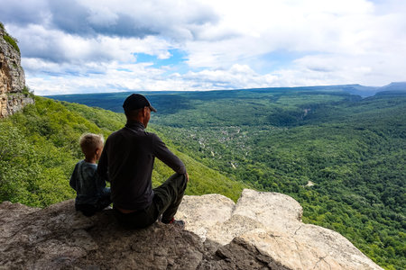 A man with a child on the background of the landscape of the Caucasus Mountains - Eagle rocks,...