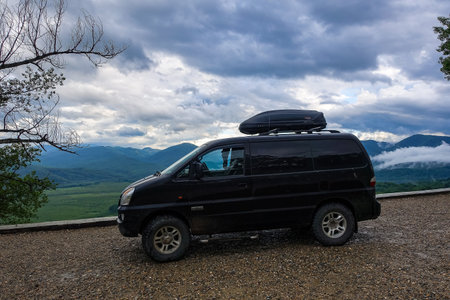 A car on the background of a view of the Lago-Naki plateau in Adygea. The Caucasus Mountains. Russia 2021.のeditorial素材