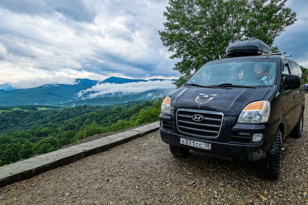 A car on the background of a view of the Lago-Naki plateau in Adygea. The Caucasus Mountains. Russia 2021.のeditorial素材