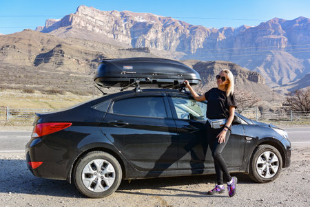A girl near the car on the background of the Caucasus mountains. Elbrus 2019 Kabardino-Balkariaの写真素材