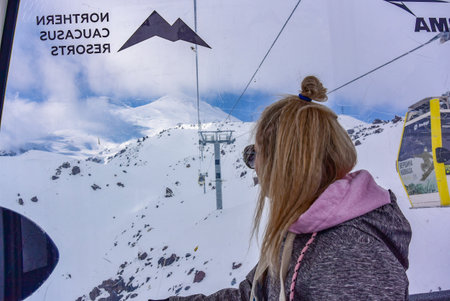 A girl on the background of Mount Elbrus in winter in the cab of a cable car. Caucasus Mountains 2019.の写真素材